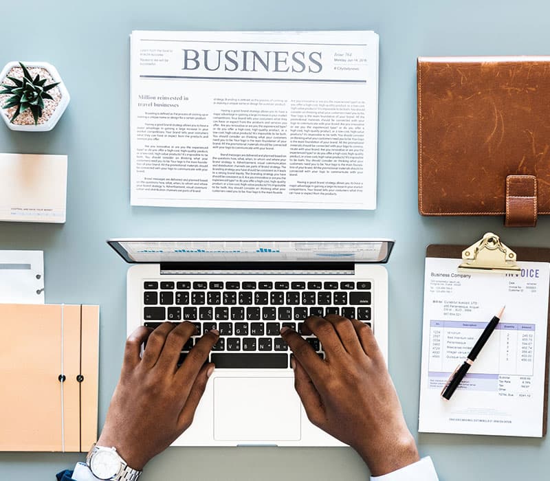 Ordinateur portable et deux mains qui tapent aux claviers pour rédiger un article marketing