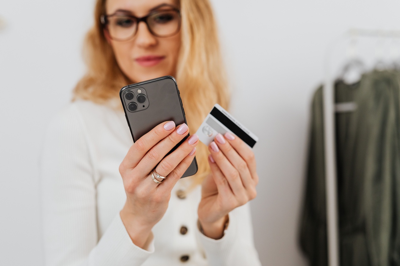 image d'une femme avec carte de crédit dans une main et un smartphone de l'autre